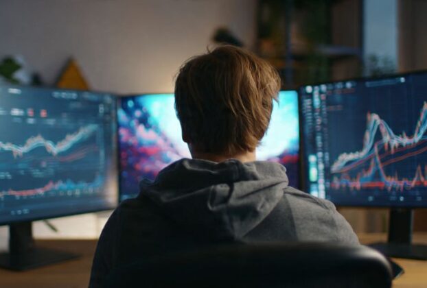 Profissional analisando métricas de marketing de afiliados avançado em múltiplos monitores.